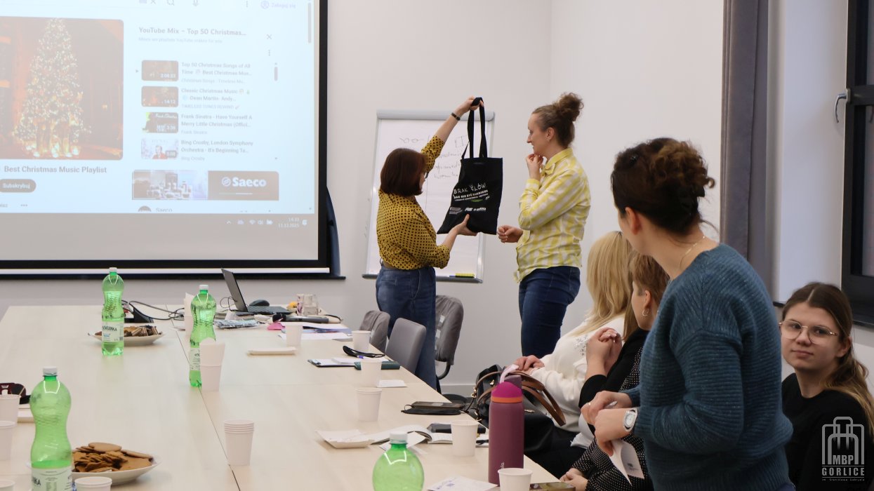 Biblioteka Gorlice, Szkolenie o odstępności dyrektorka biblioteki dziękuje za szkolenie, a prowadząca unosi torbę z gadżetami